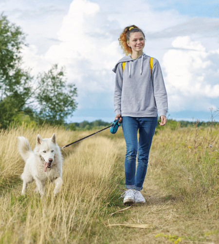 A WinniePaws dog walker on a walk with a dog outdoors